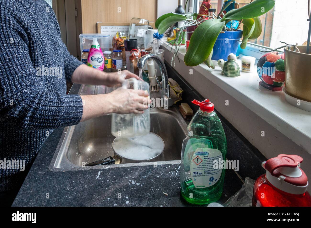 Un lasso di tempo di un uomo di mezza età che si lava in su in un lavello della cucina. Foto Stock