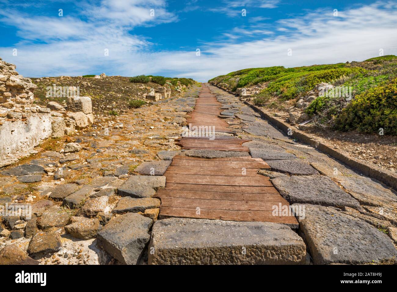 Cardus maximus, strada lastricata in basalto di epoca romana, canale fognario, sito archeologico di Tharros, comune di Cabras, Sardegna, Italia Foto Stock