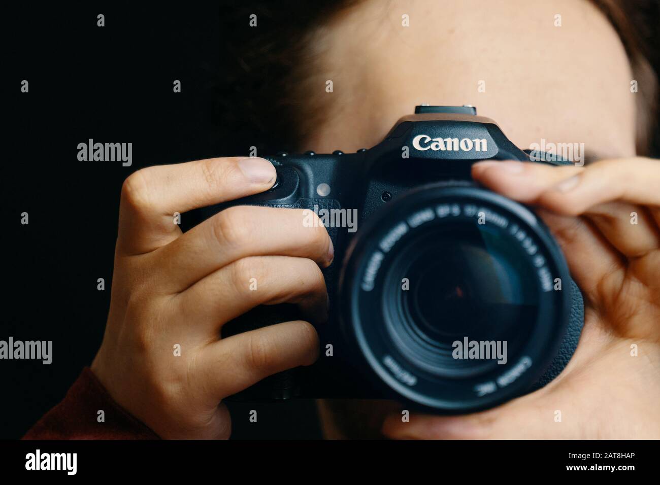 Bishkek, Kirghizistan - 15 dicembre 2019: L'uomo tiene in mano una macchina fotografica canon e scatta immagini in uno studio fotografico Foto Stock
