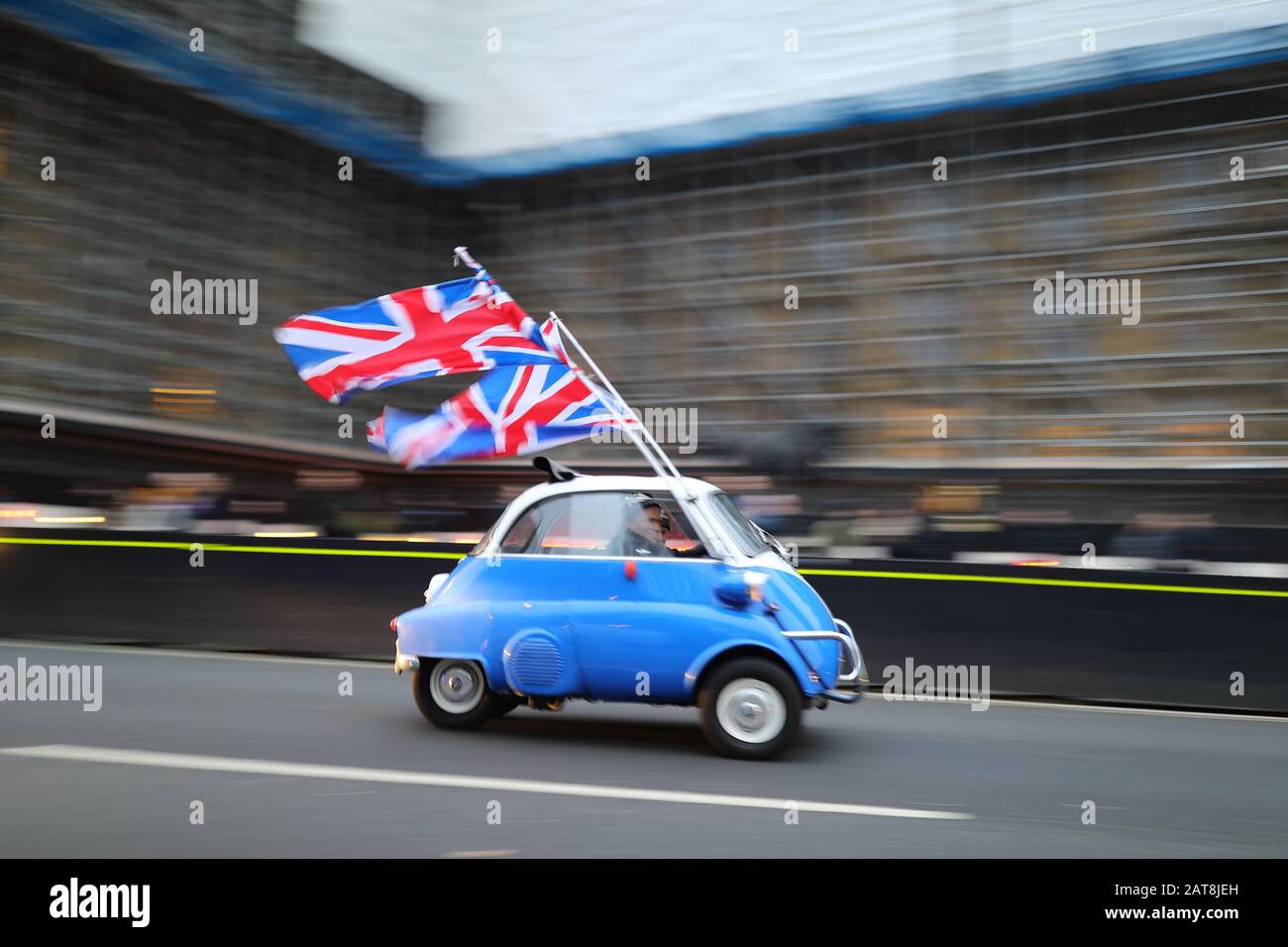 Una persona guida una BMW Isetta con bandiere dell'Unione su di essa attraverso Parliament Square, Londra, davanti al Regno Unito lasciando l'Unione europea a 11pm il Venerdì. Foto Stock