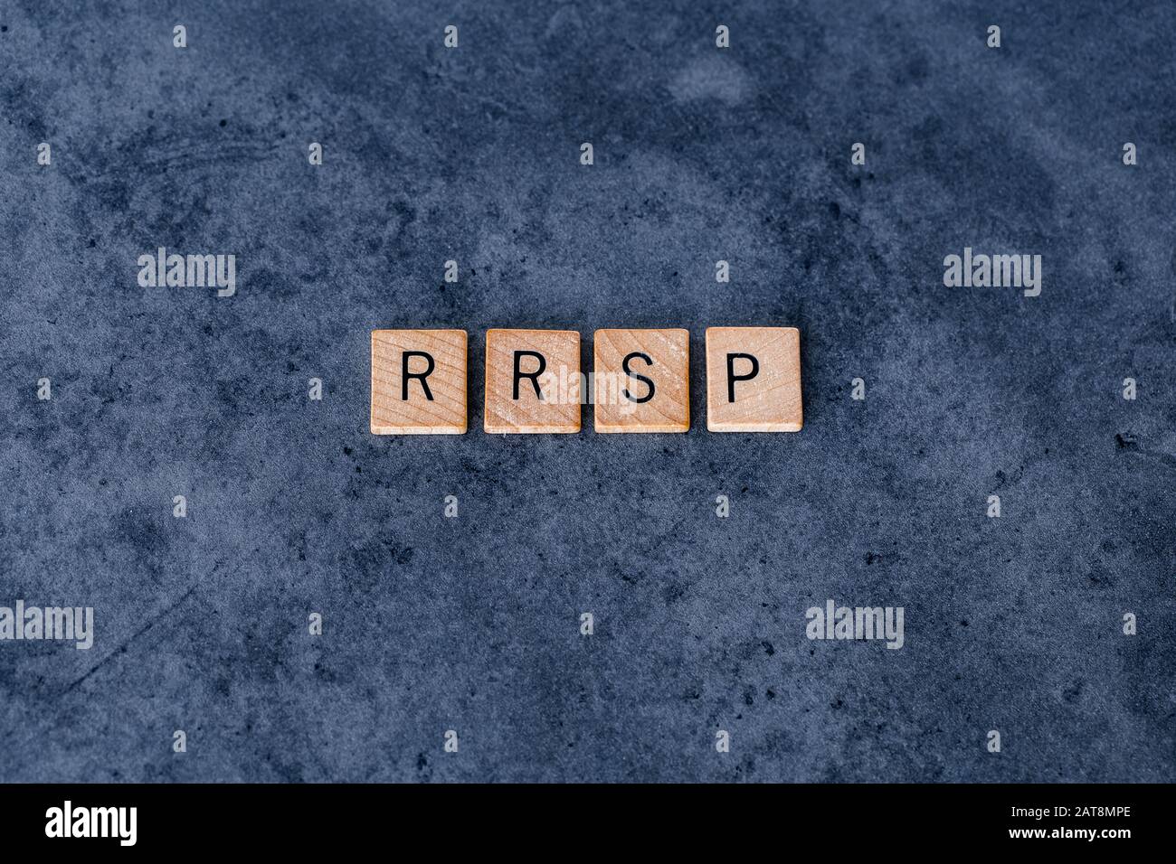 'RRSP' (Piano di risparmio pensionistico Registrato) scritto in piastrelle di legno lettera su uno sfondo scuro ruvido Foto Stock