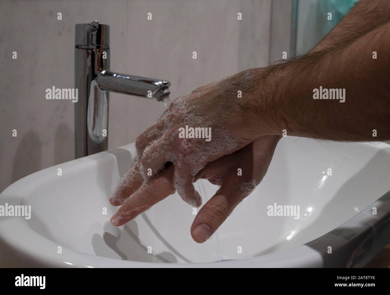 Closep sulle mani di maschio insaponata durante il lavaggio corretto come indicato DA OMS per la prevenzione di influenza e coronavirus Foto Stock