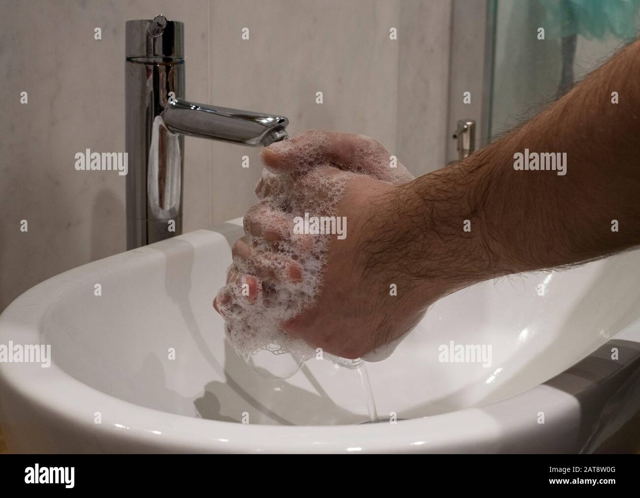 Closep sulle mani di maschio insaponata durante il lavaggio corretto come indicato DA OMS per la prevenzione di influenza e coronavirus Foto Stock