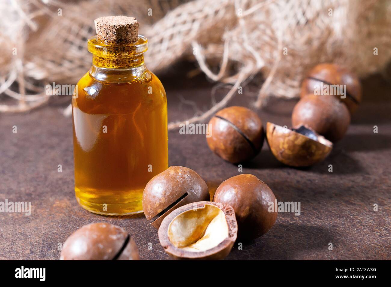 Olio di macadamia cosmetico e medicinale, su fondo marrone, olio da primo piano per donne, cosmetologia, trattamento. Sieri Naturali. Foto Stock