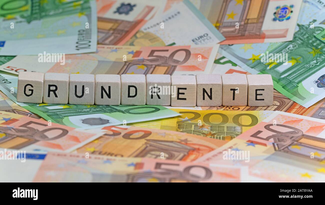 Cubi con lettere con parola tedesca Grundrente, affitto A Terra, su banconote Foto Stock