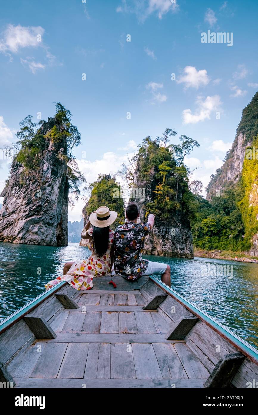 Coppia che viaggia in barca esplorando epiche scogliere calcaree nell'enorme lago nel Parco Nazionale Khao Sok, il lago Chiew lan, Thailandia Surat Thani Foto Stock