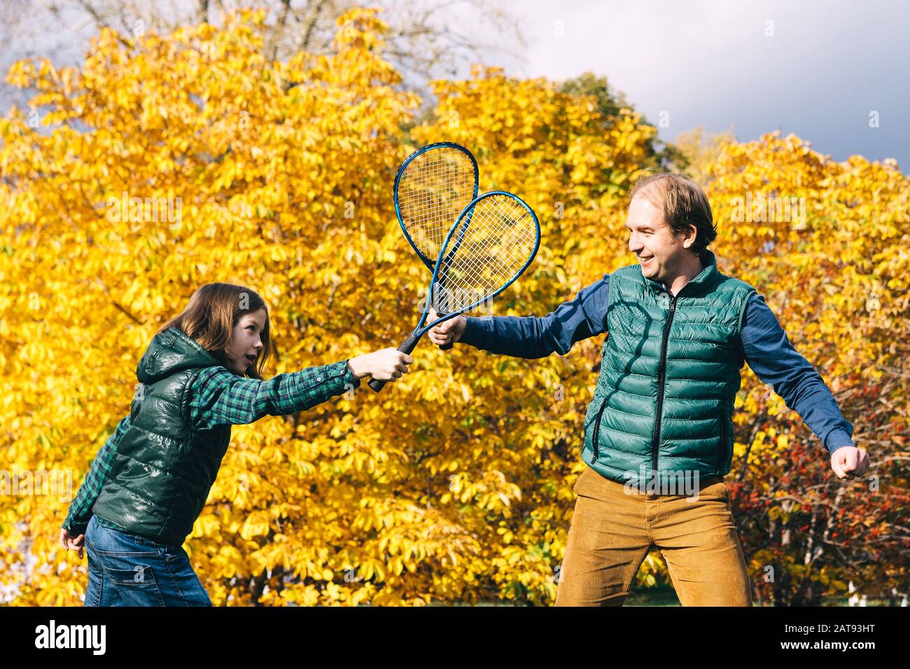 Un padre e figlio di età scolastica con badminton racchetta sta parlando Foto Stock