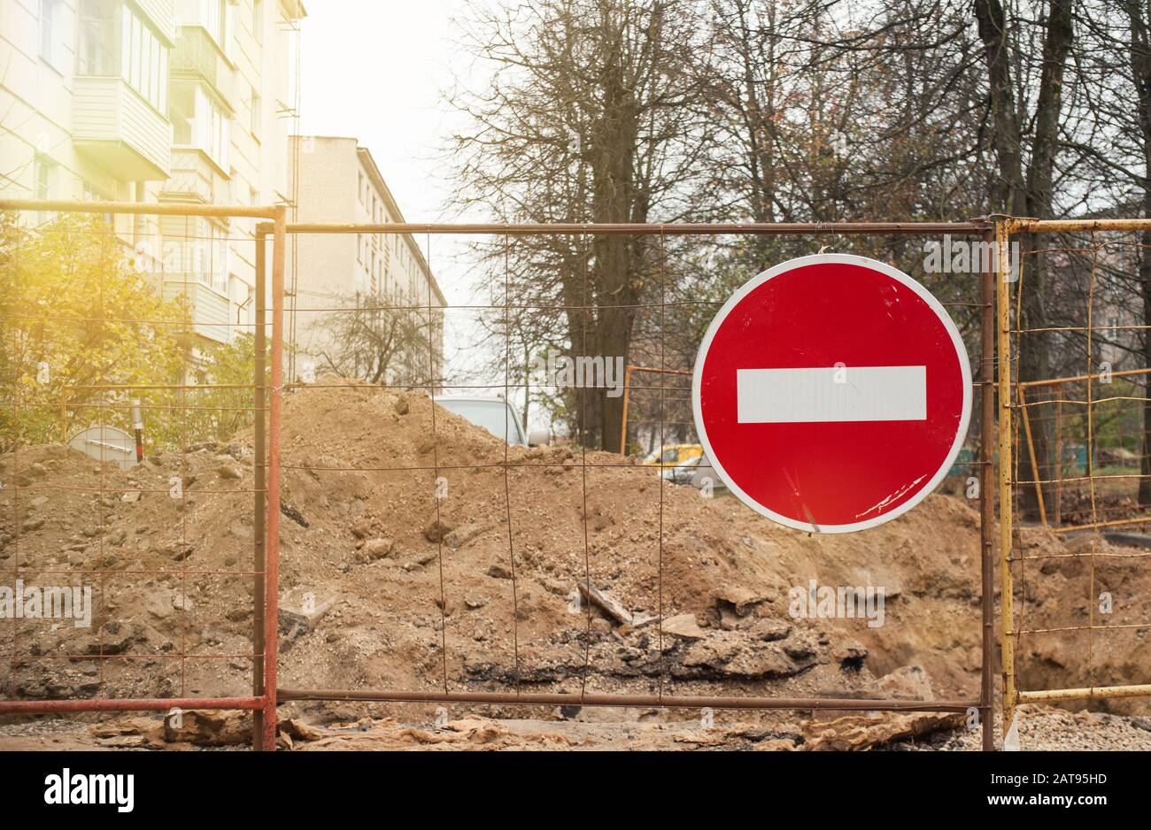 segnaletica stradale che proibisce il passaggio su una recinzione in ferro vicino ad una strada scavata Foto Stock