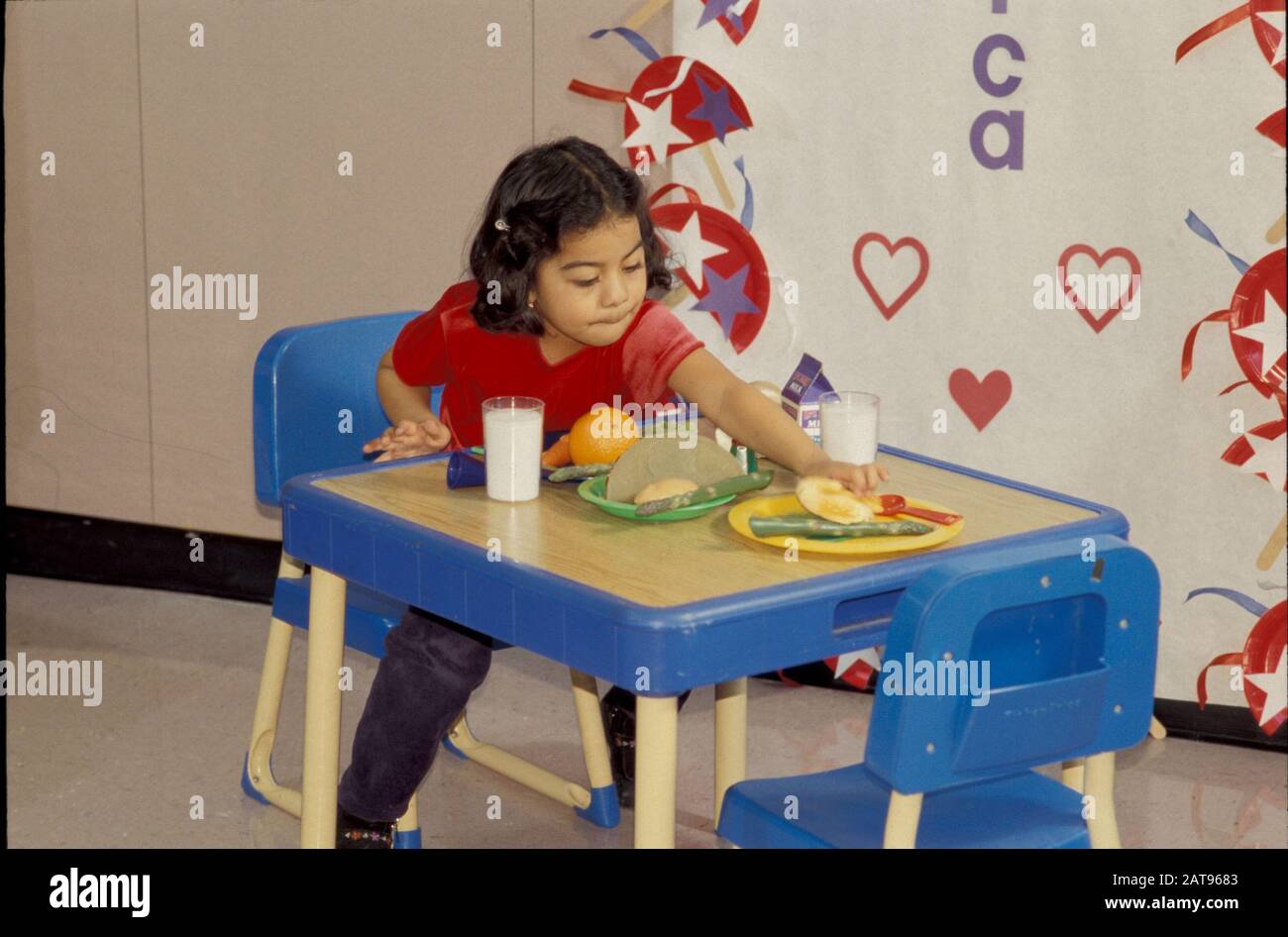 Austin, Texas: Dines di ragazza di pre-Kindergarten con amico immaginario alla scuola elementare di Walnut Creek. Novembre 2001 ©Bob Daemmrich Foto Stock