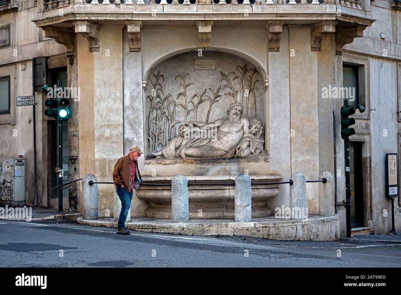 L'uomo cammina per una delle quattro fontane che rappresentano il fiume Aniene in Via delle quattro Fontane, Roma, Italia. Foto Stock