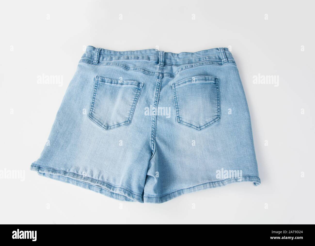 Retro di pantaloncini blu jean isolato su uno sfondo chiaro piatto stile estivo. Tasche in questo paio di pantaloncini in denim. Foto Stock