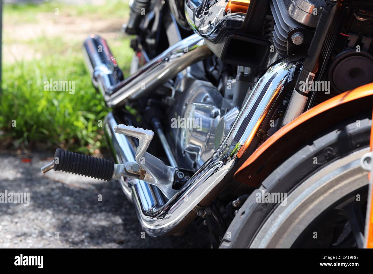 Moto: Immagine a colori molto ravvicinata di una classica harley con tubi di scarico cromati luminosi, parcheggiati all'esterno della città. Foto Stock