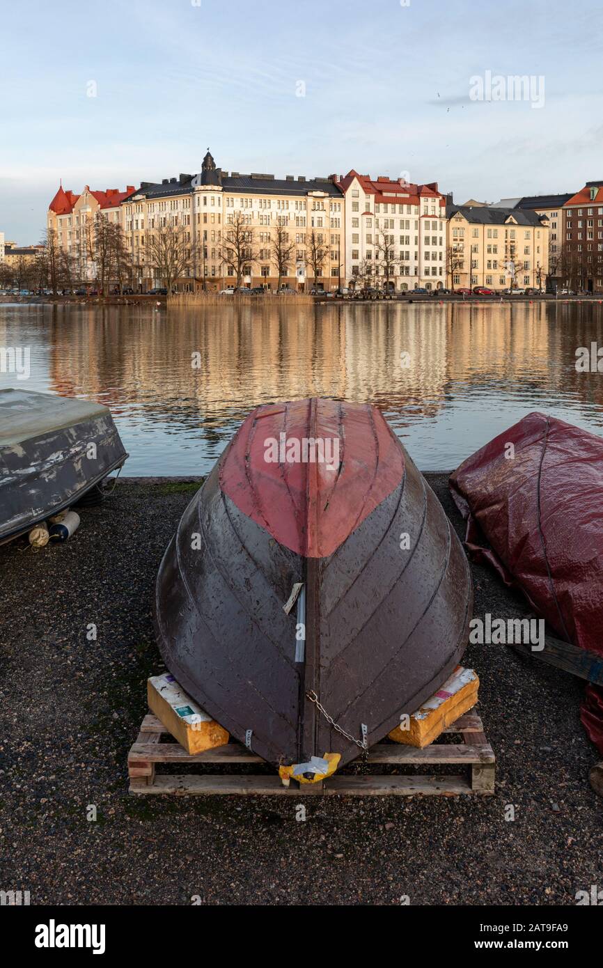 La barca a remi si è spostata dall'acqua prima che il ghiaccio copra la Baia di Kasaniemi. Quartiere di Siltasaari sullo sfondo. Helsinki, Finlandia Foto Stock