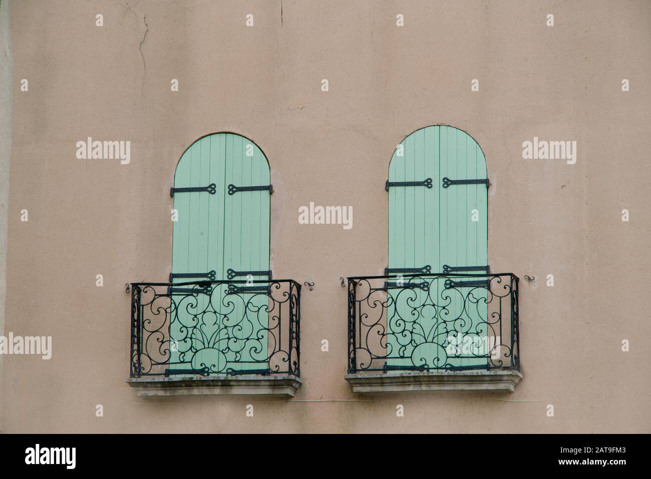 primo piano di due persiane pieghevoli verdi dietro un balcone in metallo Foto Stock