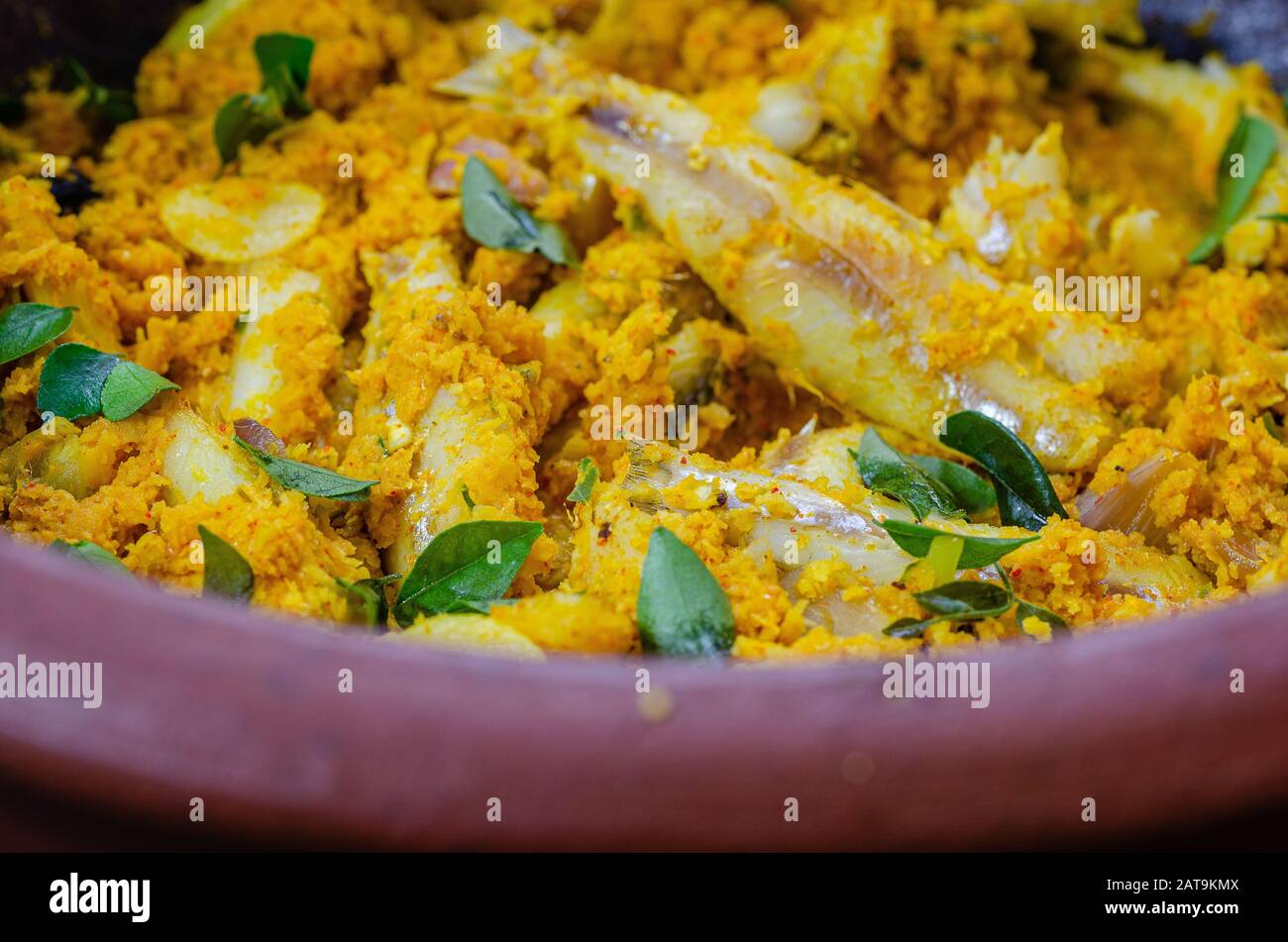 Closeup estremo di curry di pesce con cocco in una pentola di terra. Foto Stock