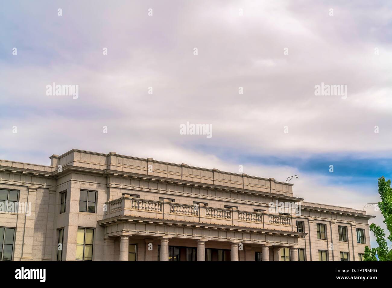 Edificio con balcone bianco e telecamera di sicurezza sul tetto contro il cielo nuvoloso Foto Stock