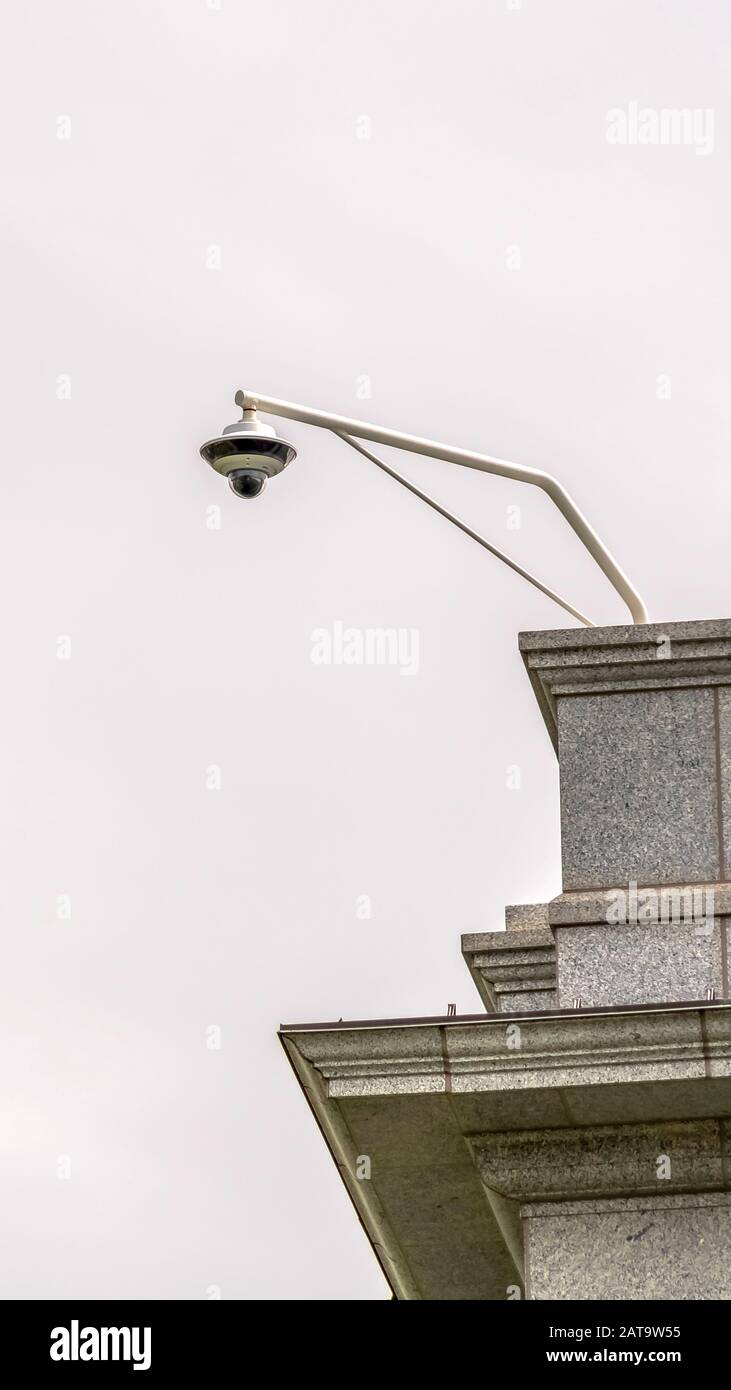 Telecamera di sicurezza tvcc verticale per esterni installata all'angolo del tetto di un edificio Foto Stock