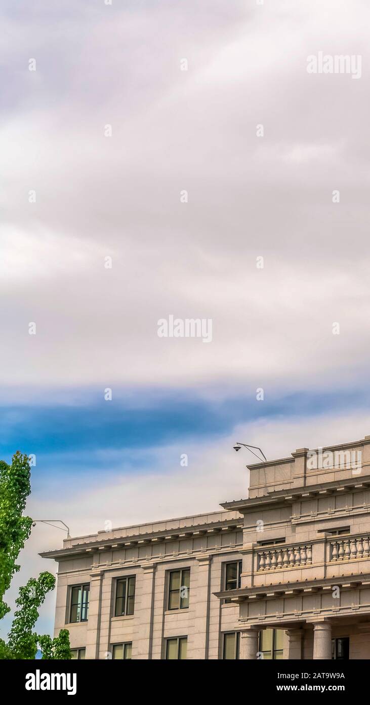 Edificio con parete bianca e telecamera di sicurezza sul tetto contro il cielo nuvoloso Foto Stock