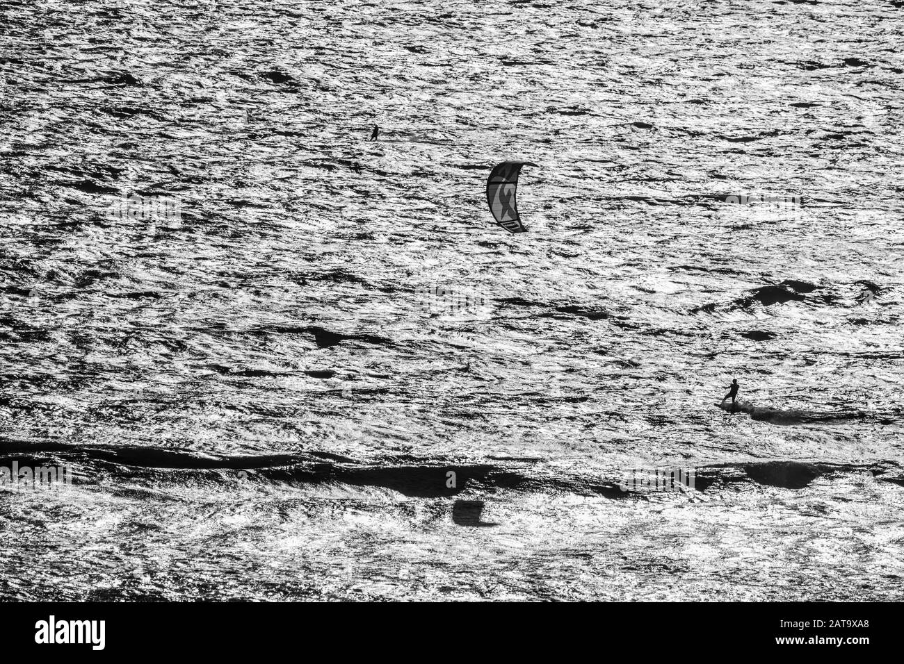 Praticare kitesurf sport estremi sulle onde del mare nell'Oceano Pacifico. Un kite surfer spinto dai forti venti provenienti da sud Foto Stock