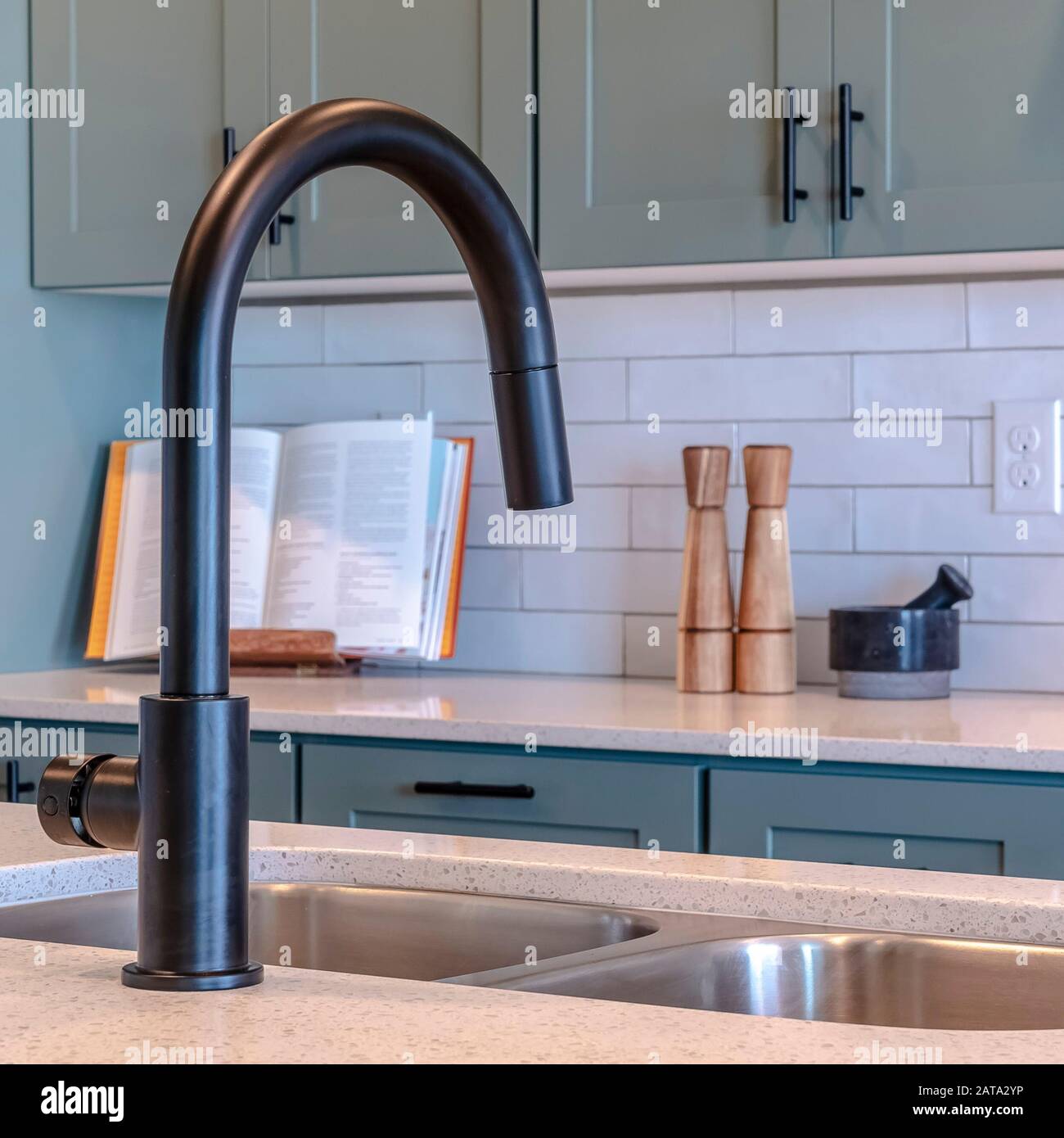Cornice quadrata cucina isola lavello e rubinetto nero contro mobili e  elettrodomestici piano cottura Foto stock - Alamy