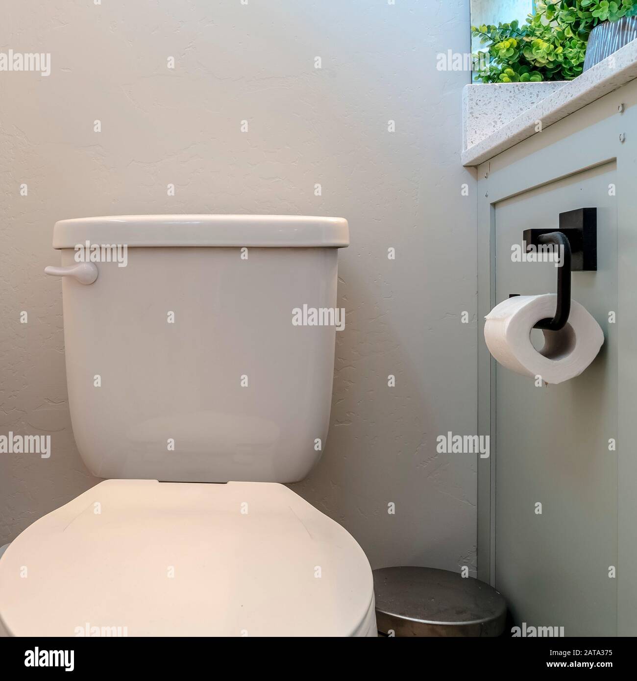 Contenitore per rifiuti di carta igienica con cornice quadrata e armadietto  con porta-tessuto contro la parete bianca del bagno Foto stock - Alamy