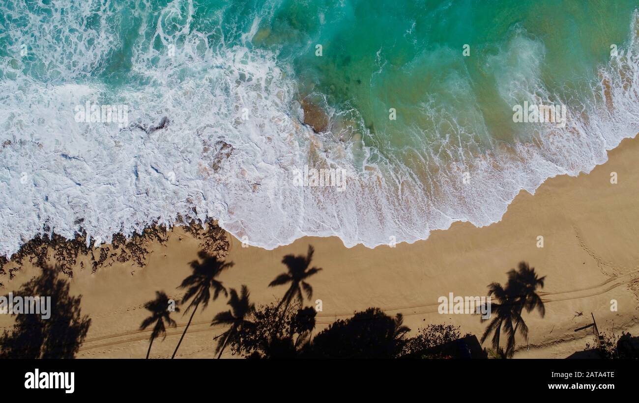 Veduta aerea dell'acqua blu brillante e surf con onde che si infrangono al Bonzai Pipeline e al Sunset Beach Park sulla North Shore, Haleiwa, Oahu, Hawaii, USA. Foto Stock