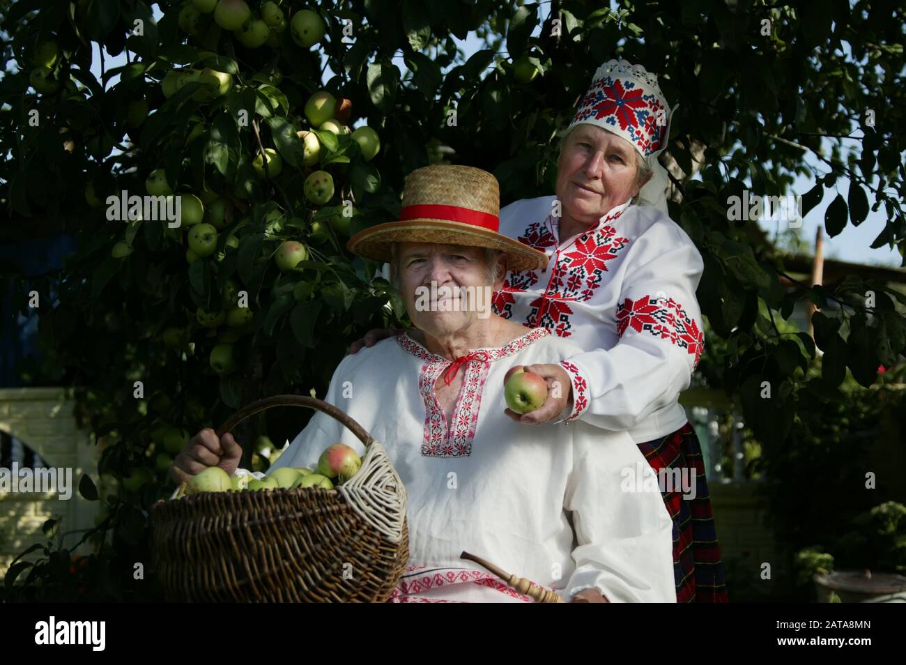 Coppia slava anziana in camicie ricamate. Nonno e donna in costumi  nazionali con un cesto di mele. Pensionati bielorussi con un raccolto Foto  stock - Alamy