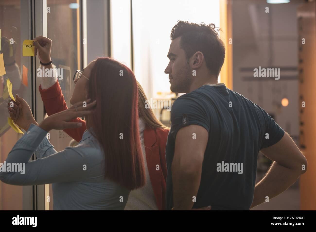 collaboratore che utilizza adesivi per la strategia di creazione del progetto di lavoro durante la sessione di brainstorming, membro qualificato del team che fa note che presentano l'idea di sta Foto Stock