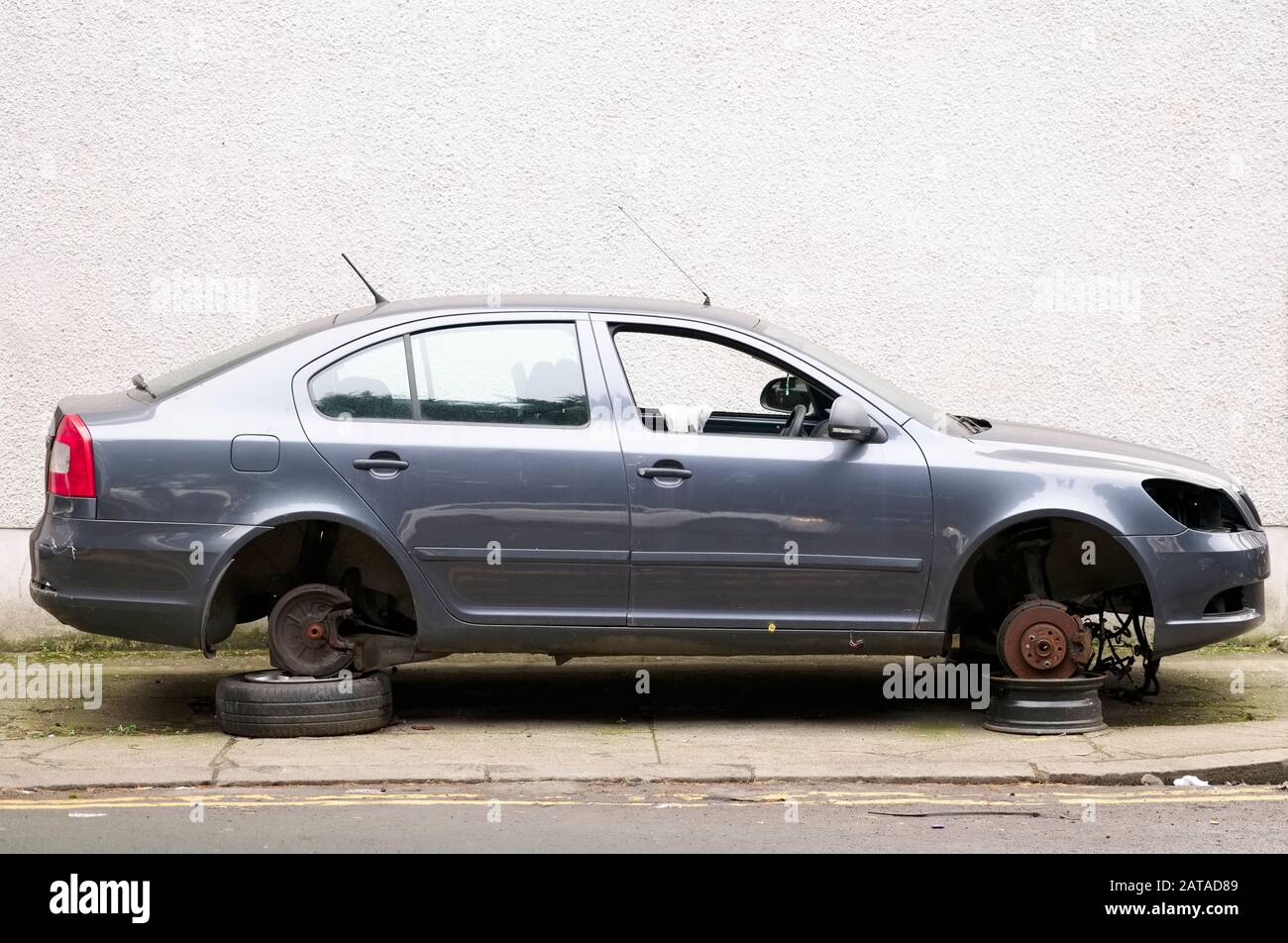 Auto con ruote rubate per la riparazione in garage sollevato sollevato sollevato su mattoni Foto Stock