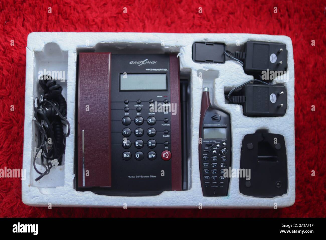 Nuovo telefono fisso su sfondo rosso Foto Stock