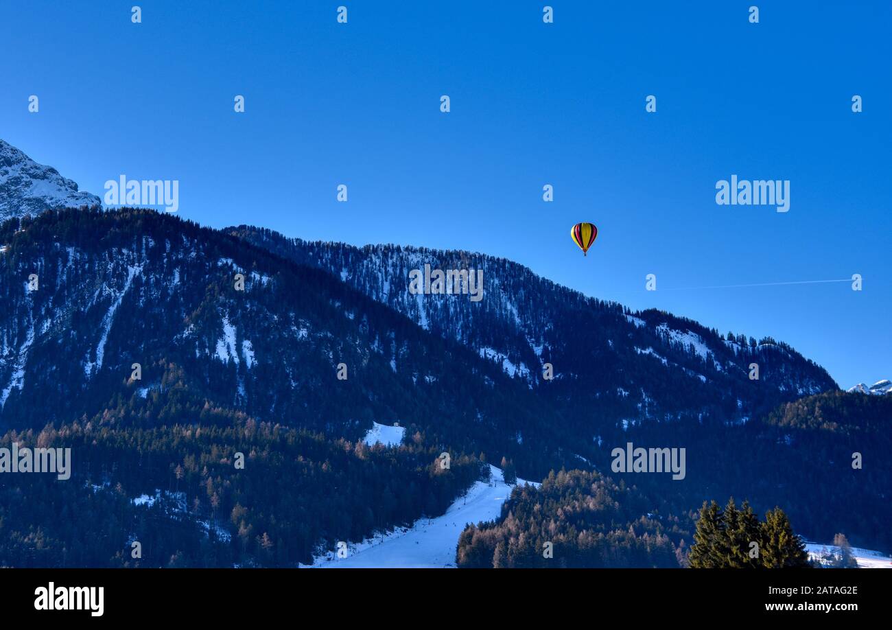 Un pallone aerostatico vola sulle piste sciistiche della valle di Dobbiaco Foto Stock