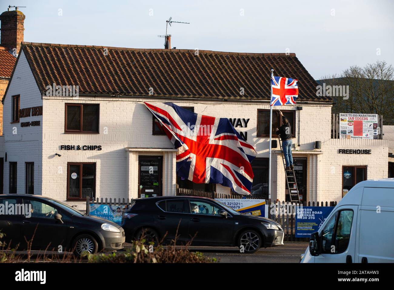 Dereham, Regno Unito. 1° Febbraio 2020. Una gigantesca bandiera dell'Unione viene prelevata dalla casa pubblica della Railway Tavern a Dereham la mattina dopo che il Regno Unito ha lasciato l'UE. Credito: Gruffydd Ll. Thomas/Alamy Live News Foto Stock