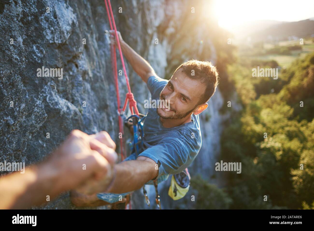 Alpinista maschile congratulandosi con il pugno dopo la salita di successo sulla montagna. Punto di vista. Foto Stock