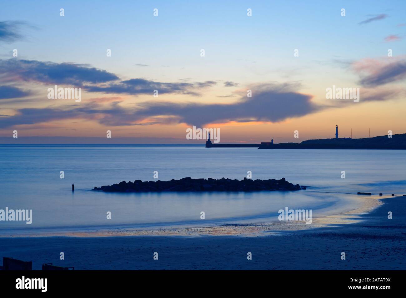 Sunrise At Aberdeen Beach, Scozia, Regno Unito. Guardando verso il porto rompere acqua e Girdleness Faro. Foto Stock