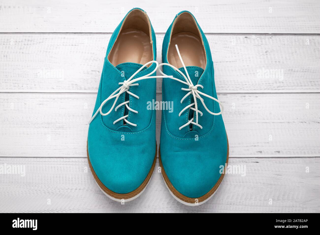Paio di scarpe scamosciate color acqua. Stivali verdi con lacci bianchi su  sfondo di legno chiaro, vista dall'alto Foto stock - Alamy