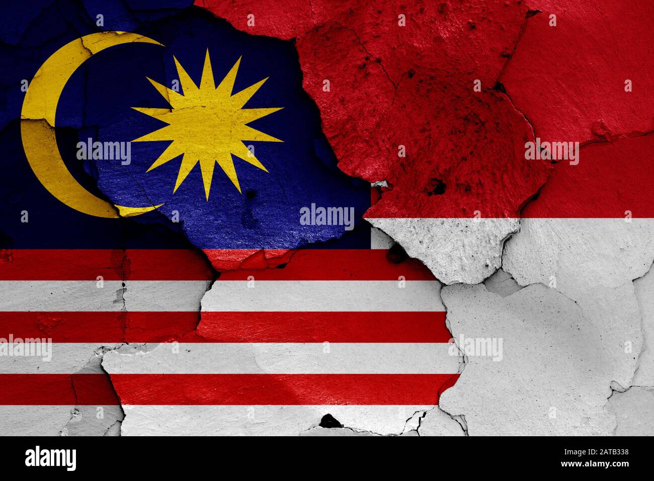 Bandiere della Malesia e dell'Indonesia dipinte su pareti incrinate Foto Stock Bandiere della Malesia e dell'Indonesia dipinte su pareti incrinate Foto Stock