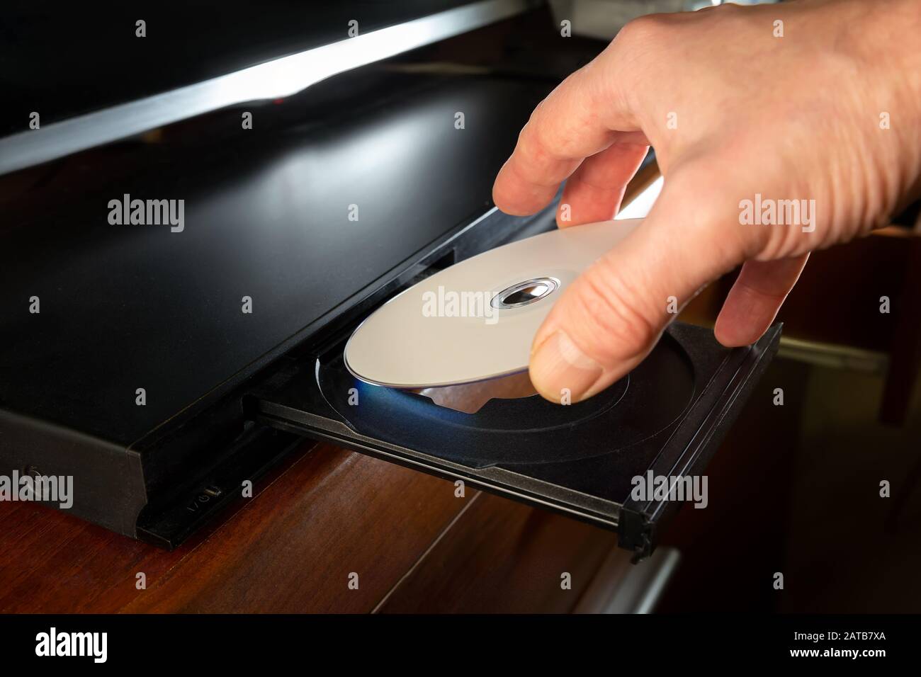 tenendo una mano l'inserto del dvd-disk sul lettore dvd Foto Stock