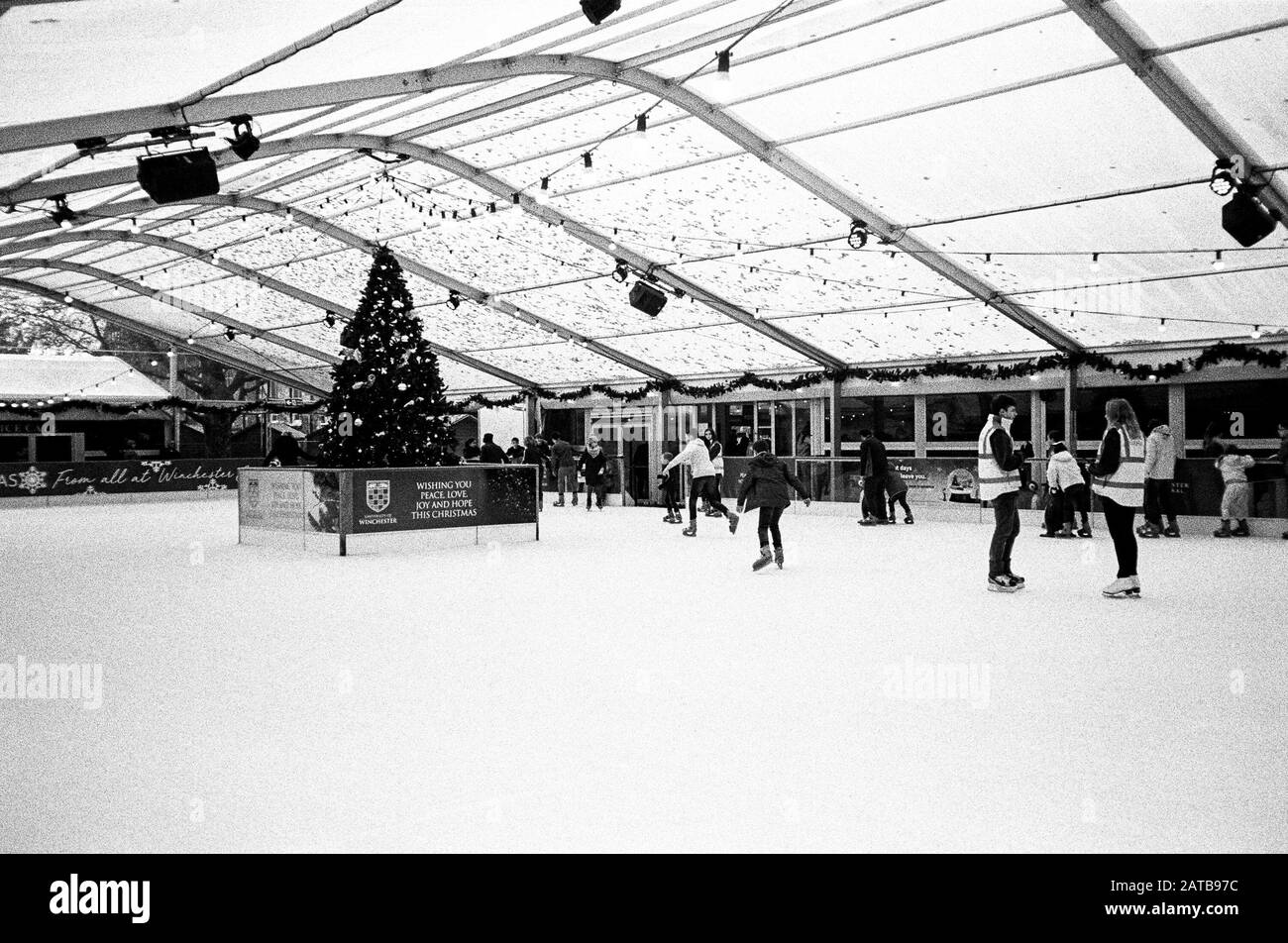 Pista di pattinaggio sul ghiaccio presso il mercatino di Natale della cattedrale di Winchester, Hampshire, Inghilterra, Regno Unito. Foto Stock
