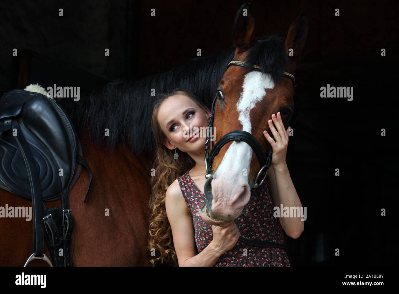 Bella donna bruna con capelli lunghi e cavallo sella Foto Stock