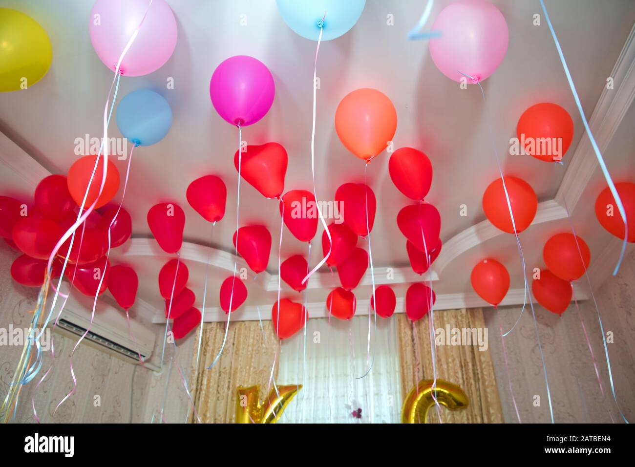 Palloncini di elio . I palloncini colorati e rossi galleggiano sul soffitto  bianco nella stanza per la festa. Decorazioni per matrimoni o feste di  compleanno per bambini Foto stock - Alamy