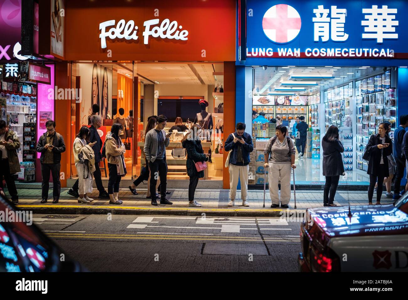 Hong Kong, Hong Kong - Novembre 2019: Persone in strada di notte in attesa di un autobus nella città di HongKong, Tsim Sha Tsui Foto Stock