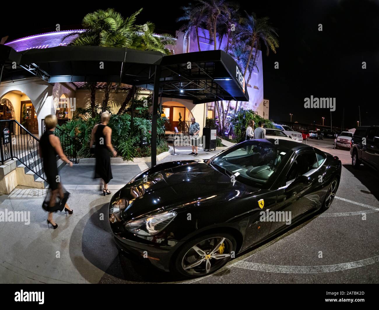 Auto Ferrari nera di fronte al ristorante Pier 22 di notte lungo il lungofiume sul fiume Manatee a Bradenton Florida Foto Stock