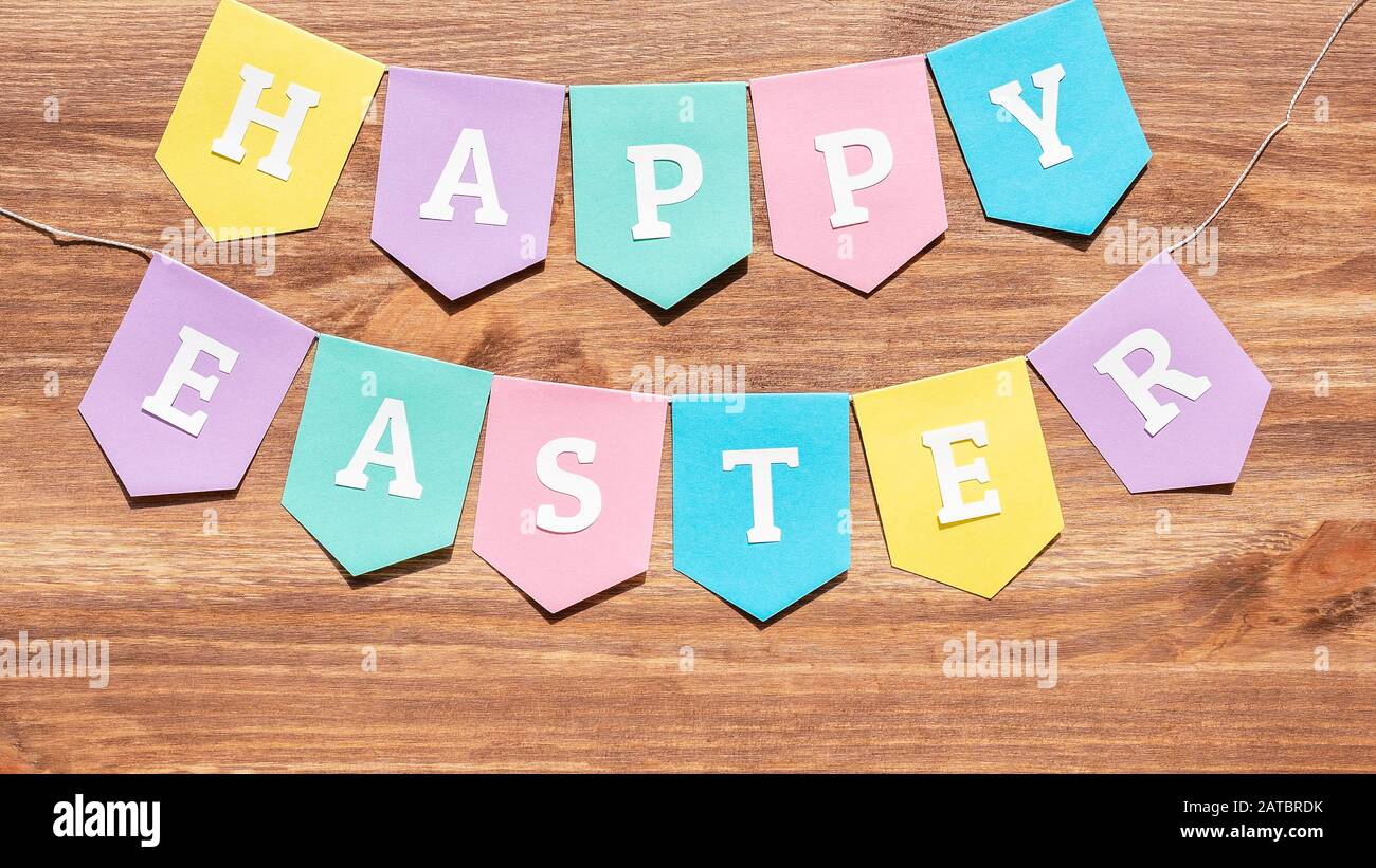 Felice sfondo di Pasqua con bandiere carta colorate sul legno Foto Stock