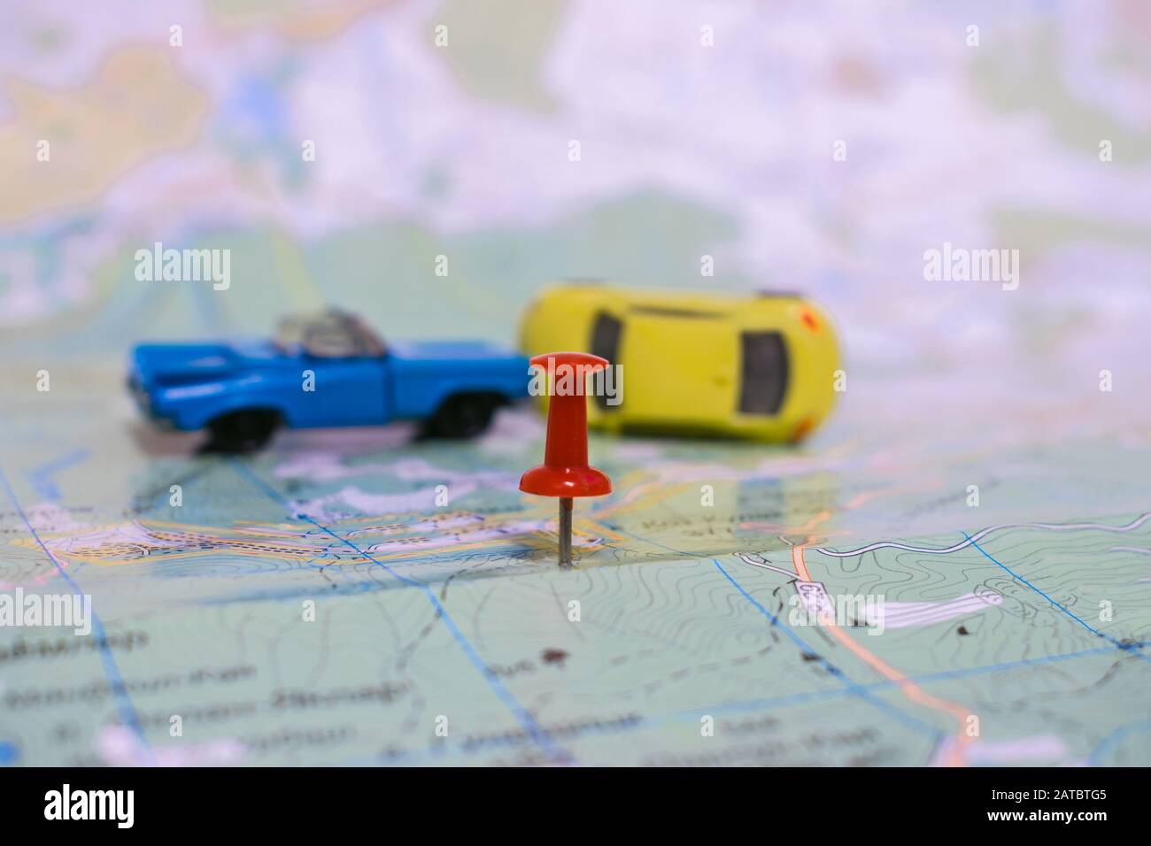 concetto di incidenti stradali. Il perno di disegno indica il luogo dell'urto sulla mappa. Collisione di due automobili. Foto Stock