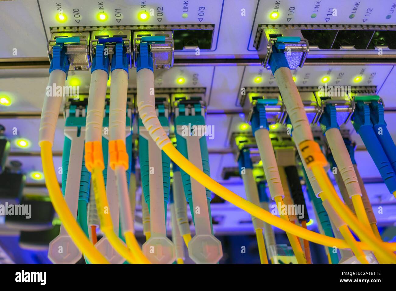 Data center. Sul pannello frontale del router Internet centrale sono accesi molti collegamenti ottici. I fili in fibra ottica sono collegati al server centrale Foto Stock