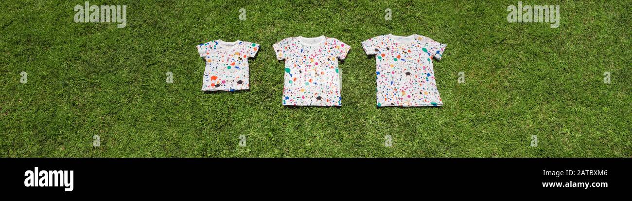 Magliette colorate sull'erba verde. Sfondo campeggio. Concettuale. Estate per bambini, studenti. Campo internazionale per alunni, studenti. Tempo libero. Attività ricreative. Sport e ricreazione Foto Stock