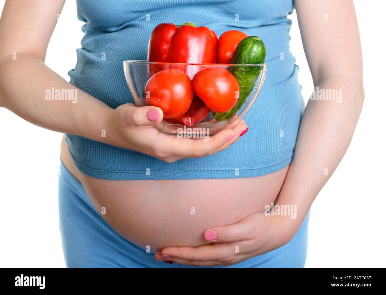 Donna incinta con verdure fresche isolato su sfondo bianco Foto Stock