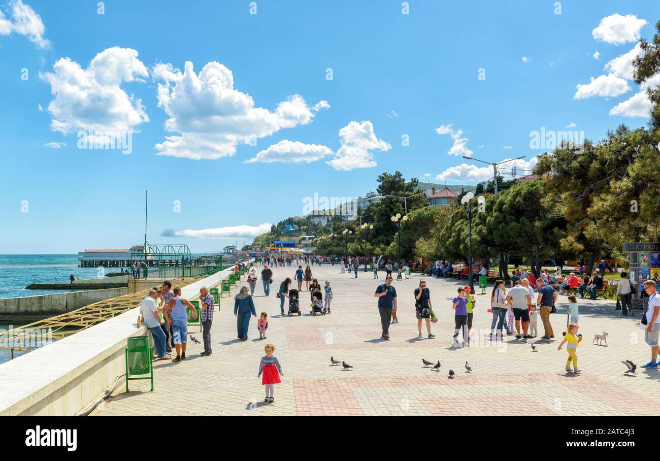 Alushta, RUSSIA - 15 MAGGIO 2016: I turisti camminano lungo la passeggiata nella città di Alushta in Crimea. Foto Stock