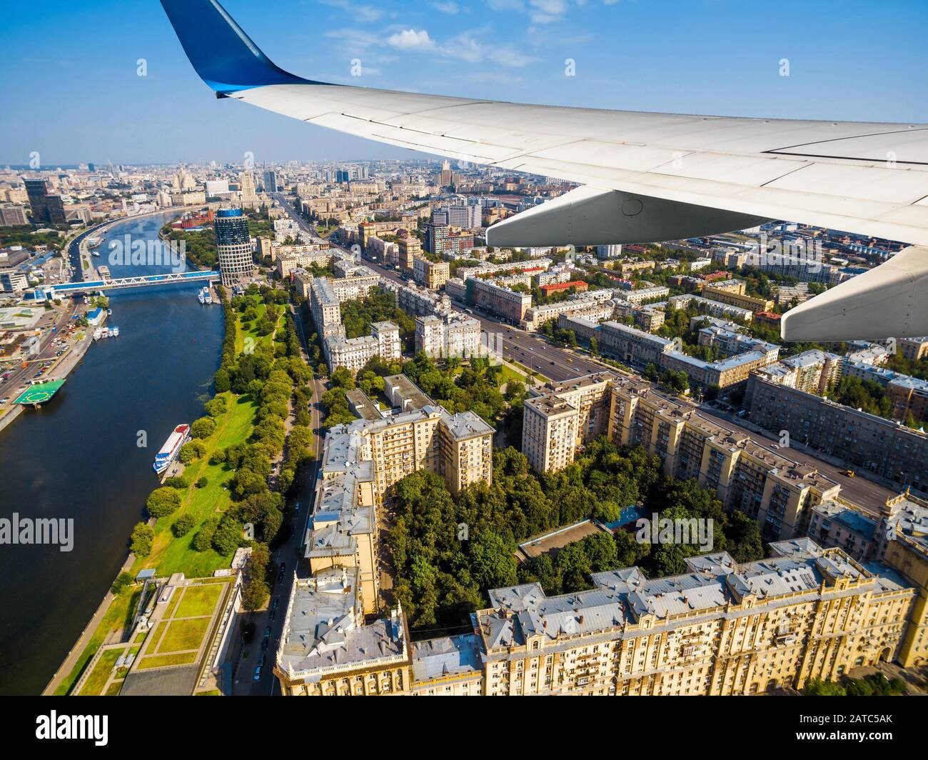 L'aereo vola sopra Mosca, Russia. Vista panoramica aerea della città di Mosca e del fiume Moskva dalla finestra dell'aereo. L'ala dell'aereo sopra Kutuzovsky Prospek Foto Stock