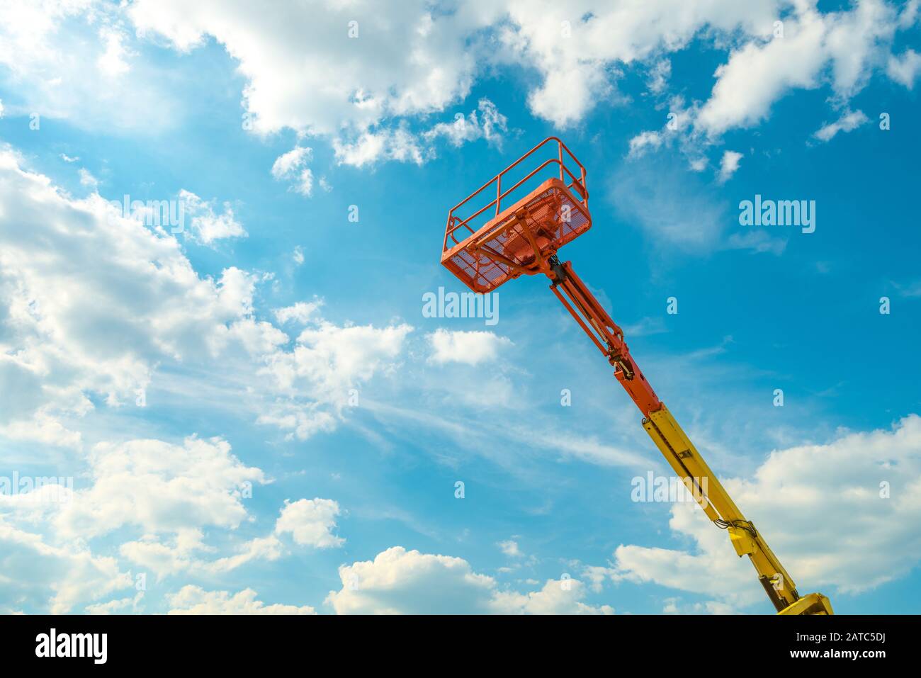 Selettore di ciliegio sullo sfondo blu del cielo. Braccio con benna di sollevamento di macchinari pesanti. Vista della piattaforma dell'ascensore telescopico in estate Foto Stock